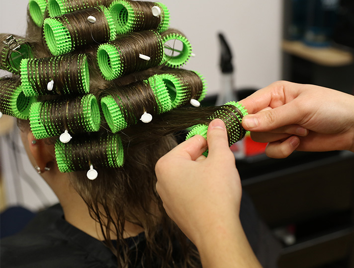 Student working at putting in curlers
